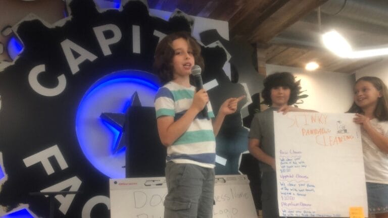 captures a moment during a student "pitch game" activity, likely at a program related to entrepreneurship or innovation